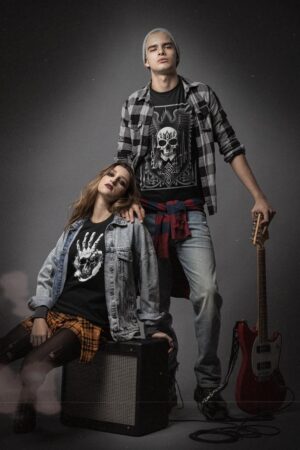 Ein Paar posiert neben einem Winged Skull - Herrenshirt in der dKip Metal-Szene.